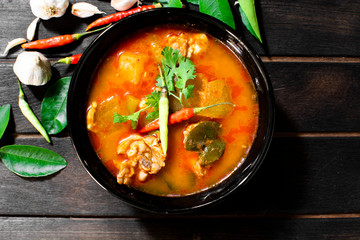 Chicken curry hatched on a dark wooden cup