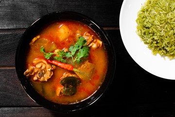 Chicken curry hatched on a dark wooden cup