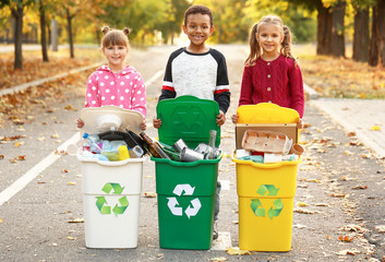 Little children collecting trash outdoors. Concept of recycling