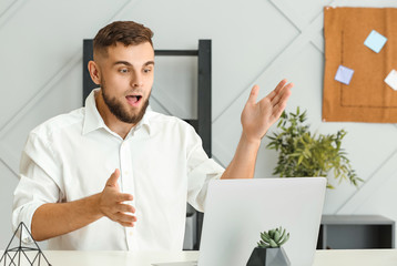 Surprised young businessman working in office