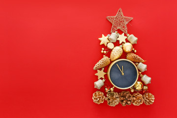 Christmas tree made of alarm clock and decor on color background