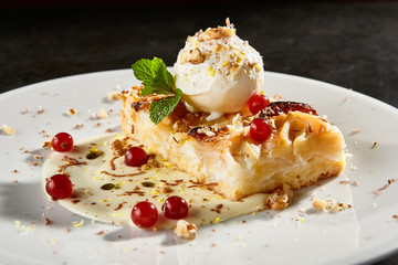 Apple pie slice with ice cream scoop side view