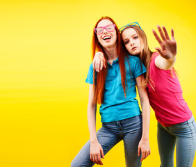 Fototapeta premium lifestyle people concept: two pretty young school teenage girls having fun happy smiling on yellow background