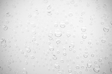 Raindrop water dew drop on glass wet white gray blue background.