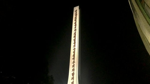 Night Time Shot Of Pointy Arch With Communist Propaganda On It. Pyongyang, North Korea
