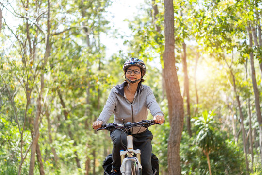 Senior asian woman riding bikes in park