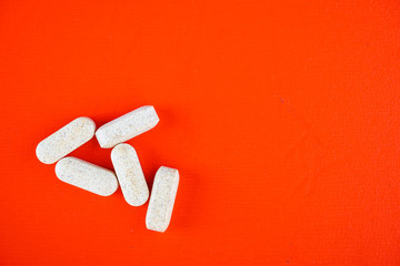 Brown capsules on a red background. Medicine and health care concept