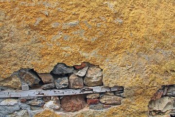 Background texture of a typical building wall of yellow stucco and brick in Athens, Greece with copy space.