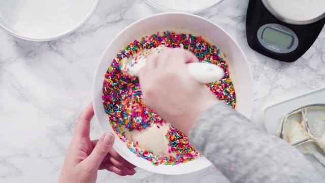 Flat lay. Step by step. Mixing in colorful sprinkles into the cake batter to make funfetti cake.Flat lay. Step by step. Mixing in colorful sprinkles into the cake batter to make funfetti cake.