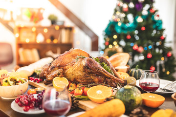 Roasted  chicken or turkey with sauce and grilled autumn vegetables: corn,pumpkin  on wooden table, top view, frame. Christmas or Thanksgiving Day food concept.