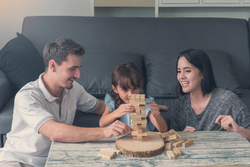 happy family and Daughter playing the wooden blocks tower at home