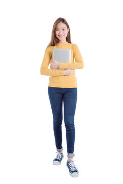 Full length of young asian beautiful girl holding notebook computer and smiles over white background