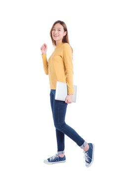 Full length of young asian beautiful girl holding notebook computer and smiles over white background