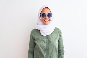 Obraz premium Young Arab woman wearing hijab and summer sunglasses over isolated background with a happy and cool smile on face. Lucky person.