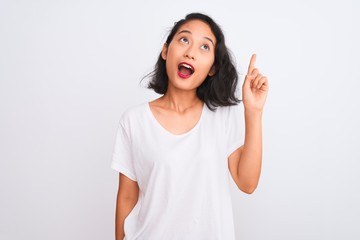 Young chinese woman wearing casual t-shirt standing over isolated white background pointing finger up with successful idea. Exited and happy. Number one.