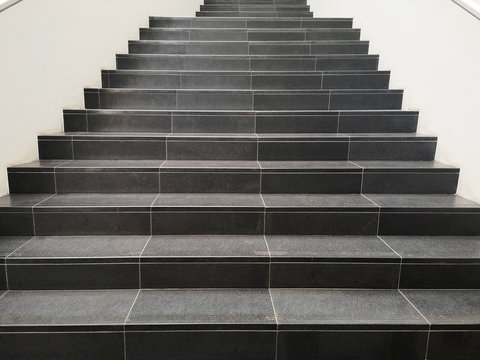 Staircase with black marble stone stairs viewed in perspective. Abstract modern architecture or interior photo in minimalism style.