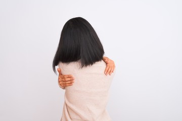 Young chinese woman wearing turtleneck sweater standing over isolated white background Hugging oneself happy and positive from backwards. Self love and self care