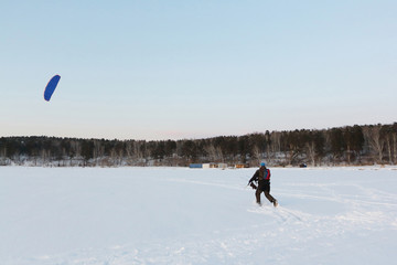 Man controls a blue kite in winter, Ob reservoir, Novosibirsk, Russia