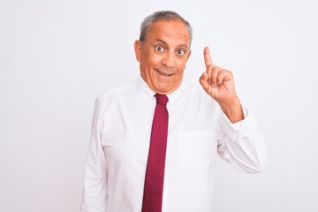 Senior grey-haired businessman wearing elegant tie over isolated white background pointing finger up with successful idea. Exited and happy. Number one.