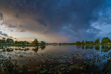 Lake view evening of dark clouds moving in heavy raining above lotus lake, sunset with rain storm above Krajub reservoir, Ban Pong, Ratchaburi, Thailand.