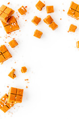 Salted caramel pieces - paradoxical sweets - on white background top view frame copy space