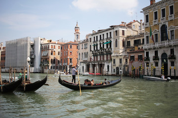 Fototapeta na wymiar Gondolas travelling on Grand Canal Venice surrounding by historical attractive building, Venice, Italy, Commercial advertisement for day trip boat in Europe