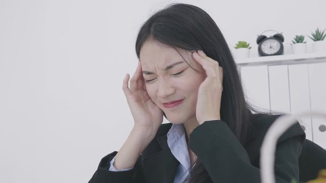 Young asian businesswoman having headache while working in office