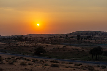 Orange desert sunset across the sand dunes in Ras al Khaimah, United Arab Emirates near Dubai. Luxury Travel.