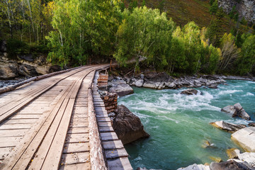 Wooden bridge over the Chuya river, near the rapids Behemoth. Mountain Altai, Russia