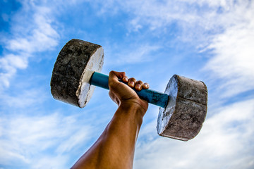 Man practicing with a old dumbbell. Exercise for good health.