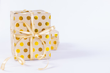 Closeup gold gift box with a gold bow on white background. Boxing day or birthday concept.