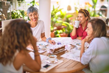 Young beautiful girl smiling happy and confident sitting dinking cup of coffee at terrace