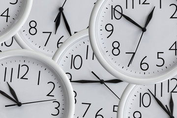 Background from set of white analog round office clocks of different sizes showing various time