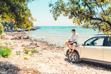 man with coffee cup standing near car at sea summer beach