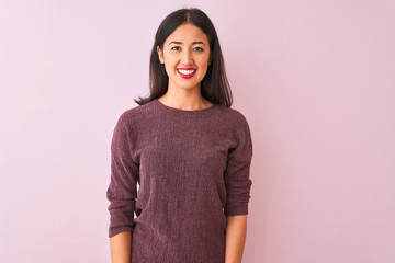 Young chinese woman wearing purple sweater standing over isolated pink background with a happy and...