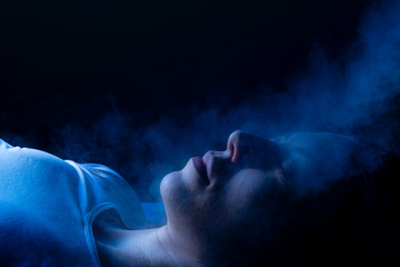 Obraz na płótnie Canvas Beauty treatment of face with ozone facial steamer in beauty center. Blue backlight.