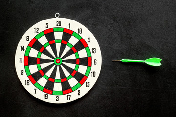 Goal achievement concept. Dartboard and arrows or dart on black background top view copy space