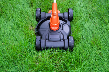 Lawn mower electric mower mowing hight grass in field, yard