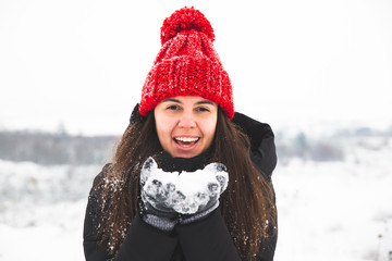 woman in red hat with bubo holding snow in hands