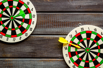 Goal achievement concept. Dartboard and arrows or dart on dark wooden background top view copy space