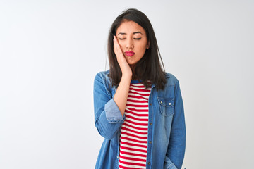 Young chinese woman wearing striped t-shirt and denim shirt over isolated white background thinking looking tired and bored with depression problems with crossed arms.