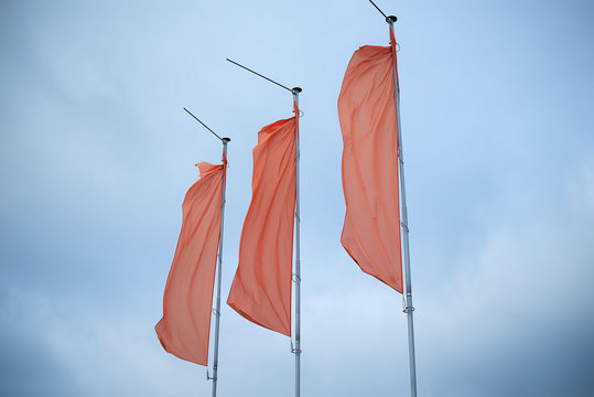 three red flags in the blue sky flutter in the wind