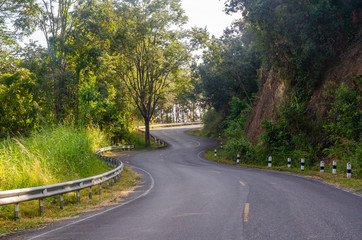 Obraz premium Curved road among forest in the rural road area