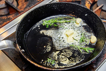 butter, garlic and herbs are cooked in a pan