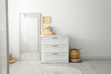 Modern room interior with white chest of drawers