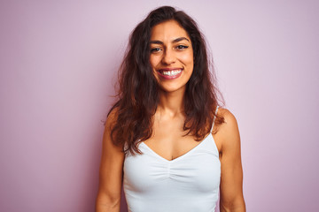 Young beautiful woman wearing white t-shirt standing over isolated pink background with a happy and cool smile on face. Lucky person.