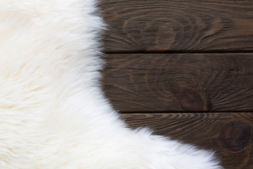 Soft white fur on brown wooden background.