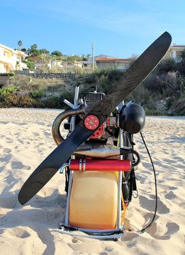interesting image of petrol engine and propeller with protection for paragliding sail  by the sea