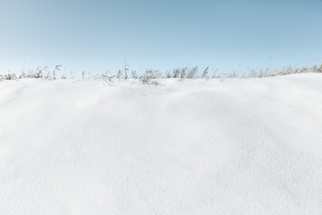 Fototapeta na wymiar Snow slide covered with fresh snow against a blue sky