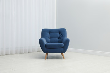 Comfortable armchair near window indoors. Stylish interior element